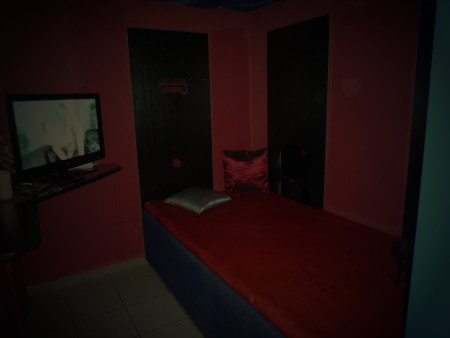 Rotes Zimmer mit Liege, Kissen und einem Fernseher. Die Fotoseite nennt es Dark.