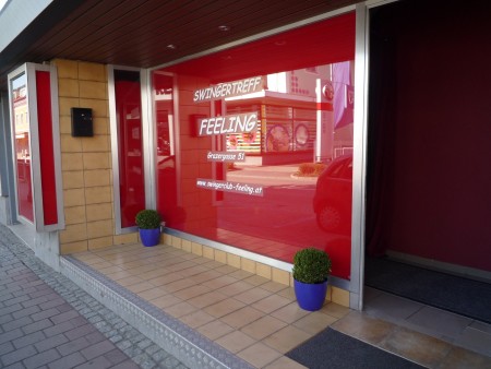 Eingang mit roter Glasfront. Aufschrift Swingertreff Feeling, Grazergasse 51.