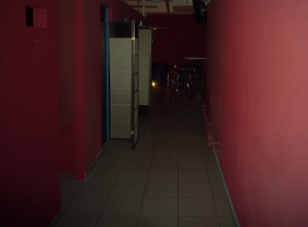 Roter Flur mit Fliesen und Türen zu den Räumen.